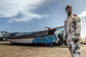 Djibouti coastguard commander Ismail Hassan Dirieh with one of the boats seized from smugglers.  By Luis TATO (AFP)