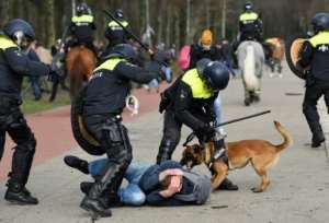 Dutch anti-riot police officers react during a demonstration against the government and anti-covid measures at the Malieveld in The Hague on March 14.  By JOHN THYS (AFP)