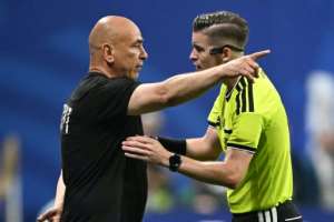 Egypt head coach Hossam Hassan (L) speaks with French referee Francois Letexier during the World Cup last-16 match against Argentina..  By ROBERTO SCHMIDT (AFP)