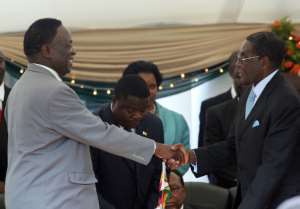 Emmerson Mnangagwa was once a key figure in the Mugabe regime. This file picture from 2009 shows Mnangagwa, left, being congratulated on his appointment as defence minister.  By ALEXANDER JOE (AFP)