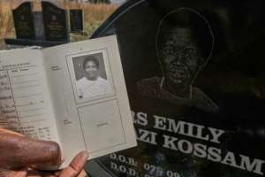 Enduring portrait: Jessica Magilazi displays the passport photo used to create the artwork on the tombstone.  By Jekesai NJIKIZANA (AFP)