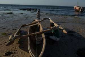 Esheya Talume, 38, repairs his boat. He escaped to Pemba three months ago.  By Alfredo Zuniga (AFP)