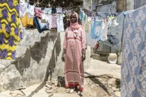 Fatou Ngom ekes by with her three children living in a single room with a shared courtyard.  By PATRICK MEINHARDT (AFP)