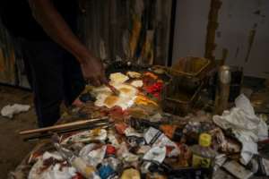 Fikru Gebremariam mixes oil paint in his studio in Addis Ababa.  By Michele Spatari (AFP)