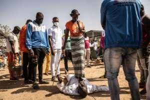 Flanked by her assistants, Adja walks on a man in a healing ritual -- she admits some cases that are beyond her powers.  By OLYMPIA DE MAISMONT (AFP)