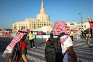 Football fans walk near the Sheikh Abdulla bin Zaid Islamic Cultural Center in Doha.  By MAHMUD HAMS (AFP)