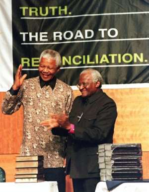Former South African President Nelson Mandela (left) received the TRC report from Archbishop Desmond Tutu.  By WALTER DHLADHLA (AFP/File)