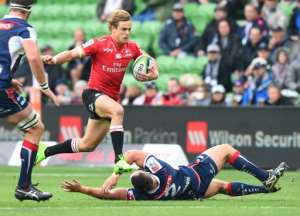 Golden Lions Andries Coetzee leaps clear of a tackle attempt by James Hanson of the Melbourne Rebels