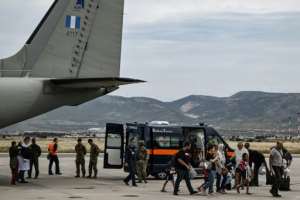 Greek nationals from Sudan arrive with a military C-27 plane at the military airport of Elefsina, south of Athens.  By Aris Messinis AFP