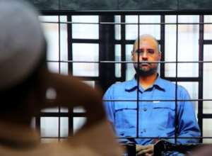 In file photo taken on May 25, 2014, Seif al-Islam, son of slain Libyan dictator Moamer Kadhafi, is questioned from behind a cage by judges.  By Mahmud TURKIA (AFP/File)