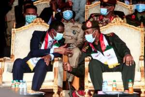 In this file photo taken on October 8, 2020, (L to R front row) General Mohamed Hamdan Daglo speaks with General Abdel Fattah al-Burhan.  By Ebrahim HAMID (AFP/File)