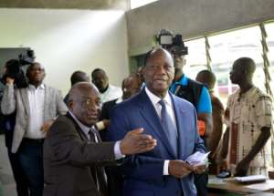 Ivory Coasts President Alassane Ouattara (R) arrives to vote at a polling station in Abidjan, on October 30, 2016, during a referendum on a new constitution