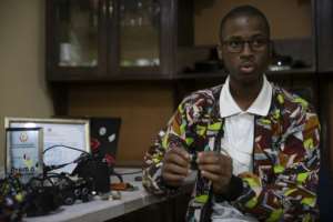 Joao Antonio Rego works on his inventions in the dining room of the family home in Matola, outside the capital Maputo.  By Amilton Neves (AFP)