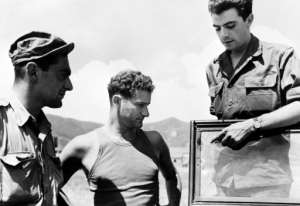 Journalists Alex Valentine (L) from Reuters, Jean-Marie de Premonville (C) and Henri de Turenne from the Agence France Presse point to bullet impacts on their jeep in 1950 during the Korean War.  By - (INTERCONTINENTALE/AFP/File)