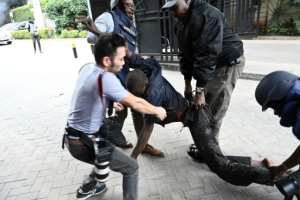 Journalists carry a victim at the scene of the attack.  By SIMON MAINA (AFP)