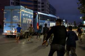 Moroccan migrants attempt to travel to Europe by jumping on the back of a vehicle at the port city of Nador in Morocco, in hopes of finding a better life on September 18, 2018.  By FADEL SENNA (AFP)