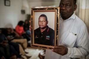 Mahajane holds a portrait of his friend Matavele, saying we want to know who is responsible for this crime.  By GIANLUIGI GUERCIA (AFP)