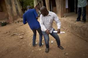Malian voters greet each other without touching their hands outside a polling booth.  By MICHELE CATTANI (AFP)