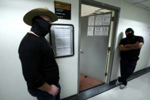 Masked federal agents at a New York immigration court.  By CHARLY TRIBALLEAU (AFP)
