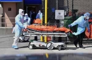 Medical staff move bodies from the Wyckoff Heights Medical Center to a refrigerated truck in Brooklyn, New York.  By Angela Weiss (AFP)