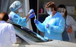Medical workers at Kaiser Permanente French Campus test a patient for the novel coronavirus, COVID-19, at a drive-thru testing facility in San Francisco, California.  By Josh Edelson (AFP)