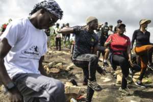 Members of trekking group Naija Adventurers take part in an aerobics session at the summit of a hill, a common occurance for sports- and fitness-mad Nigerian hikers.  By OLYMPIA DE MAISMONT (AFP)