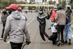 Men armed with whips and clubs grab a protester during unrest in June 2025.  By Luis TATO (AFP)