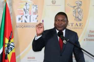 Mozambiques President Filipe Nyusi raises his ink-stained finger after voting at a polling station in Maputo.  By Roberto MATCHISSA (AFP)