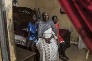 Ndeye Ndiaye (C) sits with her grandsons Fallou (L) and Bara (R) at her home in Mbour.  By PATRICK MEINHARDT (AFP)
