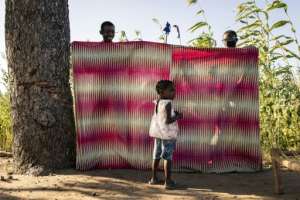 One at a time, the children, from toddlers to pre-teens, walk up to the front, shyly introducing themselves while shaking the puppets tiny hands.  By JOHN WESSELS (AFP)
