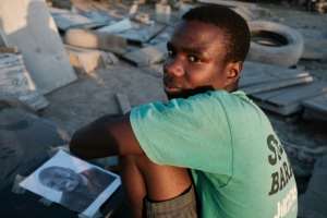 Opportunity: Tombstone carver Denzel Karombe, 19, says he had no formal training as an artist.  By Jekesai NJIKIZANA (AFP)