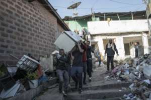 People carry a refrigerator from a house in Piassa.  By Amanuel Sileshi (AFP)