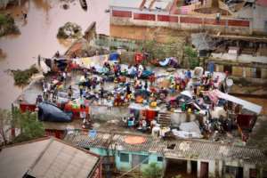 People gather on the roof of a house in Buzi. Some survivors say they have lost all their possessions. By ADRIEN BARBIER (AFP)