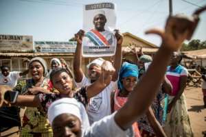 People hold a banner with an image of Gambias opposition candidate Adama Barrow as they celebrate his victory in the Presidential Elections, in Serekunda, Banjul, on December 2, 2016