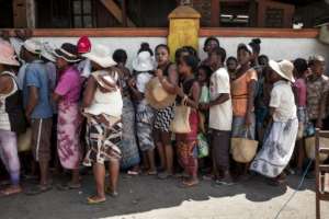 People queue up to buy cheap cooking oil and rice at a shop run by supporters of Madagascar presidential candidate Andry Rajoelina.  By RIJASOLO (AFP)