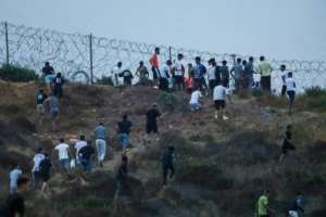 People seen gathering on hilltop on the Moroccan side of the border with Ceuta.  By Abdelmajid BZIOUAT (AFP)