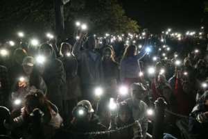 People turn on their mobile phones flashlights to observe a minutes silence to reflect on the tragic Bondi Beach shooting attack before the New Years Eve midnight fireworks display in Sydney.  By Saeed KHAN (AFP)