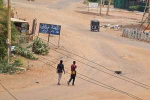 People walk on a deserted street in Khartoum.  By - (AFP)
