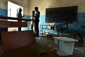 Police officers at the Hankounou polling station where ballot materials were vandalised.  By TONY KARUMBA (AFP)