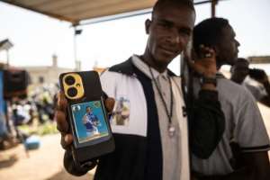 Popularity: A man shows a picture of Adja that he has downloaded on to his phone.  By OLYMPIA DE MAISMONT (AFP)