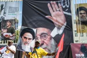 Protesters carry a banner with a portrait of the late Iranian leader Ayatollah Ali Khamenei (C) in Johannesburg.  By EMMANUEL CROSET (AFP)