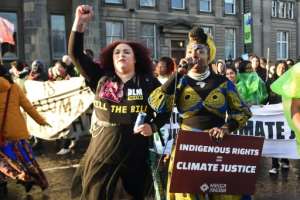 Protesters chanted Decolonise, systems change not climate change.  By ANDY BUCHANAN (AFP)