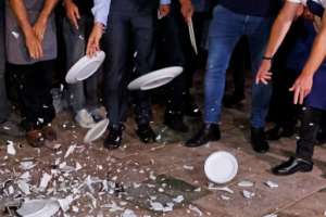 Restaurant workers in Tel Aviv break plates in protest against the new Israeli lockdown.  By JACK GUEZ (AFP/File)