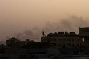 Smoke billows behind buildings in southern Khartoum -- mediators say both warring sides have violated the week-long truce.  By - (AFP)