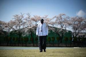 South Sudan coach Joseph Rensio Tobia Omirok supervises his athletes to a backdrop of cherry blossom as they train in Maebashi, north of Tokyo, where they were stranded after the Games were postponed.  By Philip FONG (AFP)
