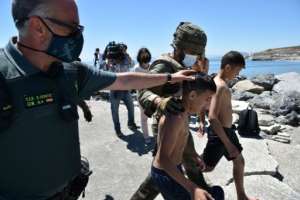 Spanish soldiers escort Moroccan minors who came ashore in Ceuta after swimming across from Moroccan territory.  By Antonio Sempere (AFP)