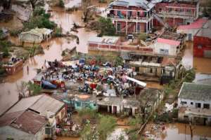 Stranded: Flood victims gather on the roof of a house in Buzi.  By ADRIEN BARBIER (AFP)