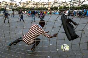 Sub-Saharan migrants play football on a makeshift pitch at the Oulad Ziane migrant camp in Moroccos Casablanca on February 19, 2018
