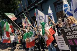 Supporters of Israel and Iranian pro-democracy activists chant slogans and hold flags in Cape Town.  By GIANLUIGI GUERCIA (AFP)