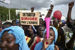 Supporters of Malis military coup, pictured in Bamako in September. The sign reads: A transition led by the army. But today, discontent about the pace of reform is growing.  By MICHELE CATTANI (AFP)